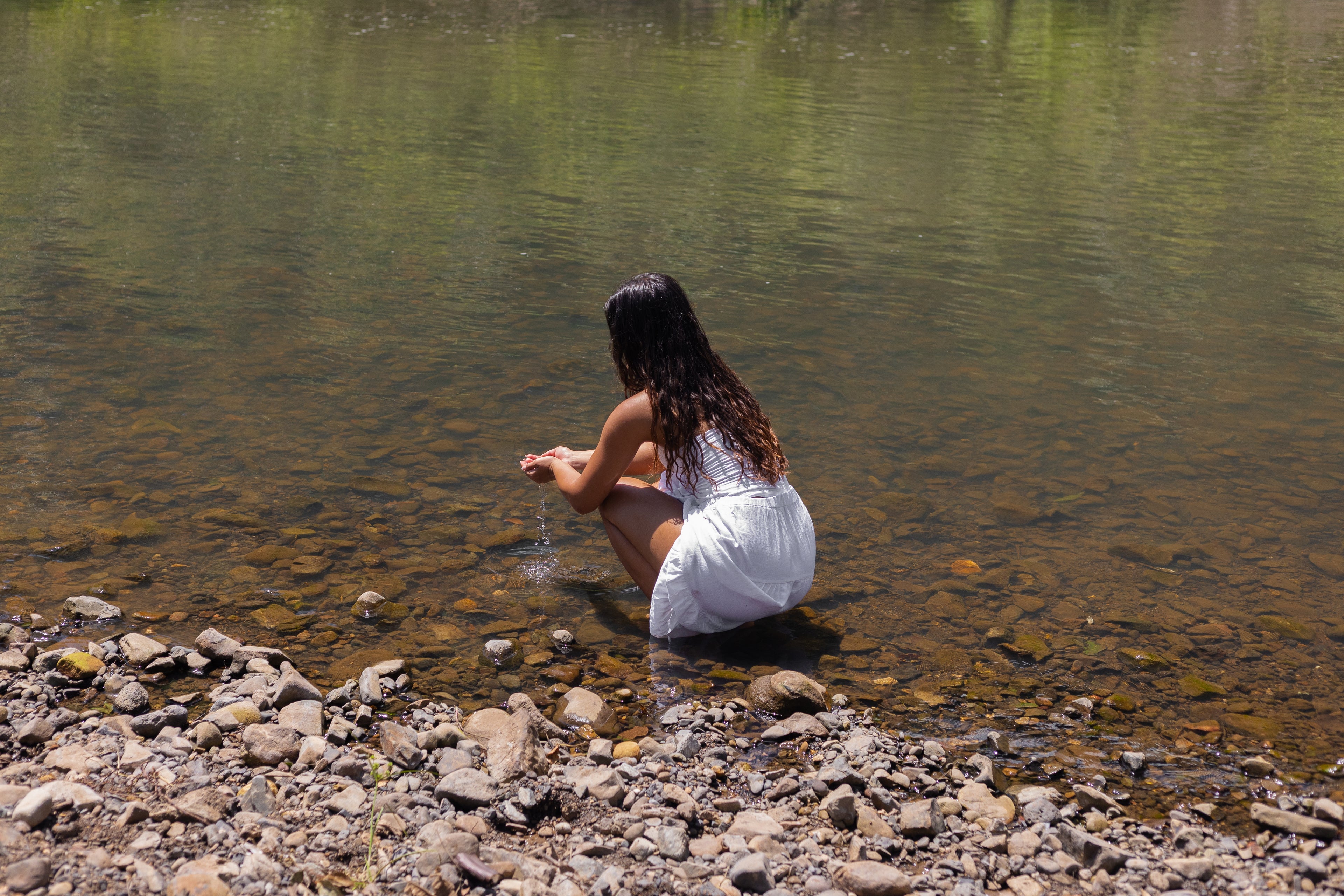 girl in creek peaceful playing with water