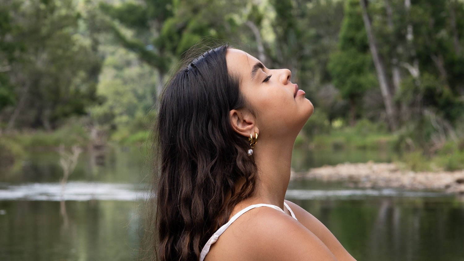 girl meditating by a peaceful creek